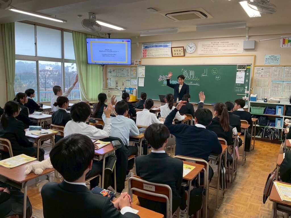 福岡県内の中学校で講演をする健楽足つぼの永川洋平氏と、真剣に聞く生徒たちの様子